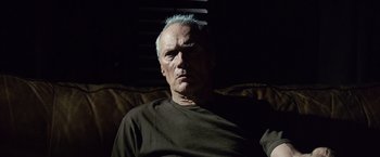 Movie still from “Million Dollar Baby” (2004), directed by Clint Eastwood – An older man sitting on a couch in a dark room; Close Up shot, Low angle