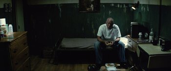 Movie still from “Million Dollar Baby” (2004), directed by Clint Eastwood – An older man sitting on a couch in a living room; Medium shot, High angle