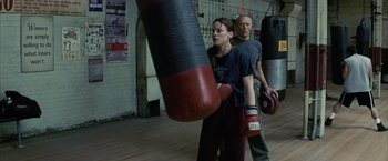 Movie still from “Million Dollar Baby” (2004), directed by Clint Eastwood – A man and a woman are boxing in a gym; Medium shot, Over the shoulder angle