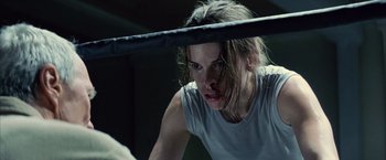 Movie still from “Million Dollar Baby” (2004), directed by Clint Eastwood – A woman in a white shirt is in a boxing ring; Close Up shot, Low angle