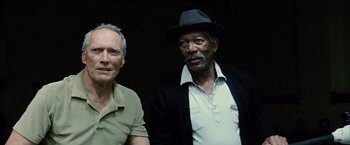 Movie still from “Million Dollar Baby” (2004), directed by Clint Eastwood – Two older men standing next to each other in a dark room; Close Up shot, Low angle