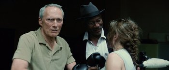 Movie still from “Million Dollar Baby” (2004), directed by Clint Eastwood – A group of people standing next to each other wearing boxing mitts; Close Up shot, Over the shoulder angle
