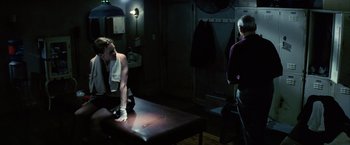 Movie still from “Million Dollar Baby” (2004), directed by Clint Eastwood – A woman sitting on top of a bench in a room; Medium shot, Over the shoulder angle