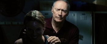 Movie still from “Million Dollar Baby” (2004), directed by Clint Eastwood – An older man and a young woman in a dark room; Close Up shot, Over the shoulder angle