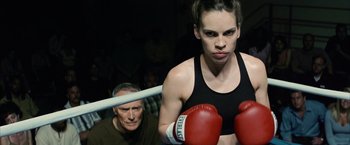 Movie still from “Million Dollar Baby” (2004), directed by Clint Eastwood – A woman wearing boxing gloves standing next to a man; Close Up shot, Over the shoulder angle