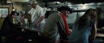 Movie still from “Million Dollar Baby” (2004), directed by Clint Eastwood – A man sitting at a counter in a restaurant; Medium shot, Over the shoulder angle