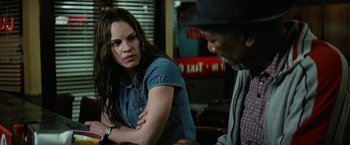 Movie still from “Million Dollar Baby” (2004), directed by Clint Eastwood – A woman sitting next to a man in a cowboy hat; Close Up shot, Over the shoulder angle