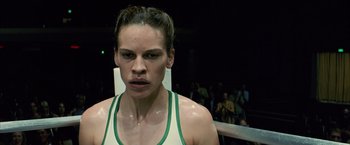 Movie still from “Million Dollar Baby” (2004), directed by Clint Eastwood – A woman in a white tank top standing in a boxing ring; Close Up shot, Low angle
