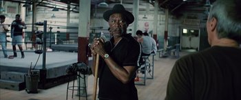 Movie still from “Million Dollar Baby” (2004), directed by Clint Eastwood – A man in a black hat holding a stick; Medium shot, Over the shoulder angle