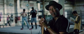 Movie still from “Million Dollar Baby” (2004), directed by Clint Eastwood – An older man holding a cane in front of a group of people; Close Up shot, Low angle