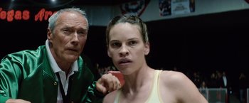 Movie still from “Million Dollar Baby” (2004), directed by Clint Eastwood – A man and a woman are standing in a boxing ring; Close Up shot, Low angle