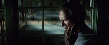 Movie still from “Million Dollar Baby” (2004), directed by Clint Eastwood – An older man talking on a phone in a dark room; Close Up shot, Over the shoulder angle