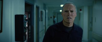 Movie still from “Million Dollar Baby” (2004), directed by Clint Eastwood – A man standing in a hallway with a woman in the background; Close Up shot, Low angle