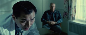 Movie still from “Million Dollar Baby” (2004), directed by Clint Eastwood – Two men sitting in a room one of which is looking at the camera and the other is sitting on a chair; Close Up shot, Over the shoulder angle