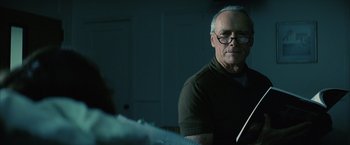 Movie still from “Million Dollar Baby” (2004), directed by Clint Eastwood – An older man wearing glasses sitting at a table in a room; Close Up shot, Low angle