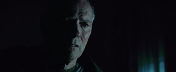 Movie still from “Million Dollar Baby” (2004), directed by Clint Eastwood – An old man with a black background and a dark background; Close Up shot, Low angle