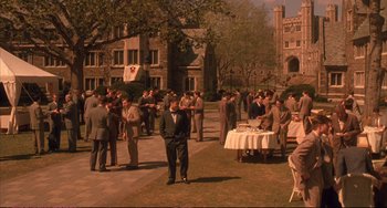 Movie still from “A Beautiful Mind” (2001), directed by Ron Howard – A group of people standing around a table; Extreme Wide shot, High angle