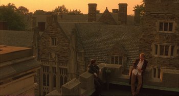 Movie still from “A Beautiful Mind” (2001), directed by Ron Howard – Two people sitting on the top of a building on a roof; Extreme Wide shot, High angle