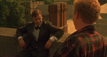 Movie still from “A Beautiful Mind” (2001), directed by Ron Howard – A man in a suit talks to another man in a plaid shirt; Medium shot, Over the shoulder angle