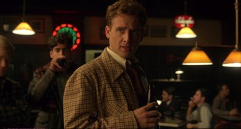 Movie still from “A Beautiful Mind” (2001), directed by Ron Howard – A man in a suit and tie standing in a room; Medium shot, Over the shoulder angle