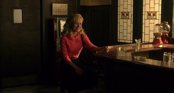 Movie still from “A Beautiful Mind” (2001), directed by Ron Howard – A woman sitting at a table in front of a window; Medium shot, Over the shoulder angle