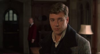 Movie still from “A Beautiful Mind” (2001), directed by Ron Howard – A man in a suit and tie standing in front of a door; Close Up shot, Over the shoulder angle