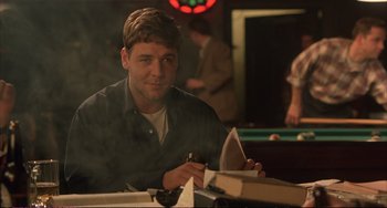 Movie still from “A Beautiful Mind” (2001), directed by Ron Howard – A man sitting at a table in front of a pool table; Medium shot, Over the shoulder angle