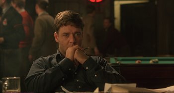 Movie still from “A Beautiful Mind” (2001), directed by Ron Howard – A man sitting at a table in front of a pool table; Medium shot, Over the shoulder angle