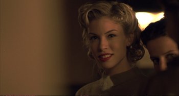 Movie still from “A Beautiful Mind” (2001), directed by Ron Howard – A beautiful woman with blonde curly hair and red lipstick; Close Up shot, Over the shoulder angle
