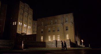 Movie still from “A Beautiful Mind” (2001), directed by Ron Howard – Two men are walking in front of an old building at night; Extreme Wide shot, Low angle
