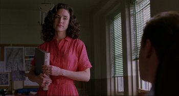 Movie still from “A Beautiful Mind” (2001), directed by Ron Howard – A woman in a red dress holding a book; Medium shot, Low angle