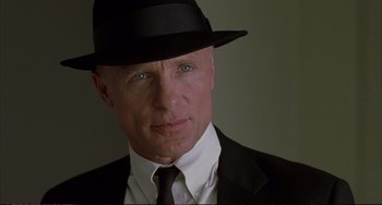 Movie still from “A Beautiful Mind” (2001), directed by Ron Howard – A person wearing a suit and a hat; Close Up shot, Low angle