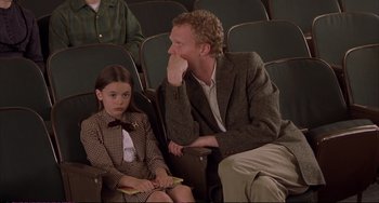 Movie still from “A Beautiful Mind” (2001), directed by Ron Howard – A man sitting next to a little girl in a theater; Medium shot, High angle