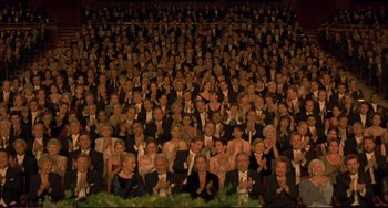 Movie still from “A Beautiful Mind” (2001), directed by Ron Howard – A large group of people wearing suits in a theater; Wide shot, High angle