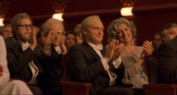 Movie still from “A Beautiful Mind” (2001), directed by Ron Howard – A man and two women sitting next to each other in a theater; Medium shot, High angle