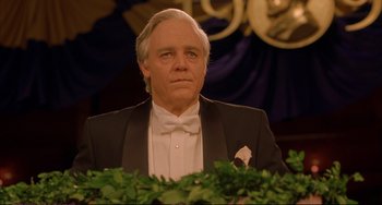 Movie still from “A Beautiful Mind” (2001), directed by Ron Howard – An older man in a suit and bow tie looks at the camera; Close Up shot, Low angle