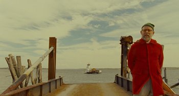 Movie still from “Moonrise Kingdom” (2012), directed by Wes Anderson – A person standing on a bridge looking out at the water; Extreme Wide shot, Over the shoulder angle