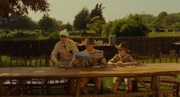 Movie still from “Moonrise Kingdom” (2012), directed by Wes Anderson – A group of young men sitting at a picnic table; Wide shot, Low angle
