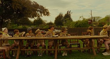 Movie still from “Moonrise Kingdom” (2012), directed by Wes Anderson – A group of scouts sitting at a picnic table; Wide shot, Over the shoulder angle