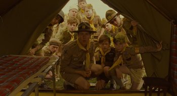 Movie still from “Moonrise Kingdom” (2012), directed by Wes Anderson – A group of young men in scout uniforms posing for a picture; Medium shot, Low angle