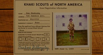 Movie still from “Moonrise Kingdom” (2012), directed by Wes Anderson – A boy scout is standing in front of an official document; Extreme Close Up shot, Overhead angle