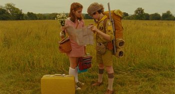 Movie still from “Moonrise Kingdom” (2012), directed by Wes Anderson – A couple of people standing in a field with a map; Medium shot, High angle