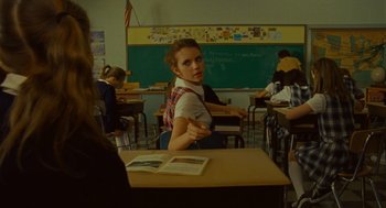 Movie still from “Moonrise Kingdom” (2012), directed by Wes Anderson – A woman sitting at a desk in front of a chalkboard; Medium shot, Over the shoulder angle