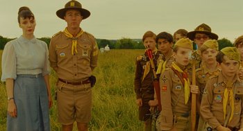 Movie still from “Moonrise Kingdom” (2012), directed by Wes Anderson – A group of young men standing on top of a grass covered field; Medium shot, Low angle