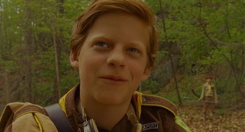 Movie still from “Moonrise Kingdom” (2012), directed by Wes Anderson – A young man with red hair wearing a brown jacket; Close Up shot, Low angle