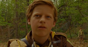 Movie still from “Moonrise Kingdom” (2012), directed by Wes Anderson – A young boy in a scout uniform looking into the camera; Close Up shot, Low angle