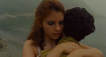 Movie still from “Moonrise Kingdom” (2012), directed by Wes Anderson – A young woman holding a young man in her arms in front of a body of water; Close Up shot, Over the shoulder angle