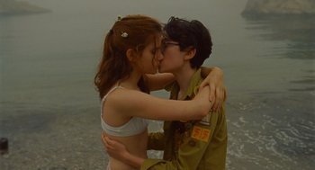 Movie still from “Moonrise Kingdom” (2012), directed by Wes Anderson – A man and a woman kissing in front of the ocean; Medium shot, Over the shoulder angle
