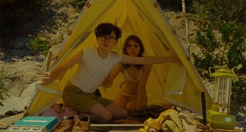 Movie still from “Moonrise Kingdom” (2012), directed by Wes Anderson – A man and a woman sitting inside of a tent; Medium shot, Low angle