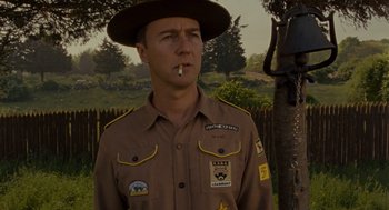 Movie still from “Moonrise Kingdom” (2012), directed by Wes Anderson – A man in uniform smoking a cigarette in a field; Close Up shot, Low angle